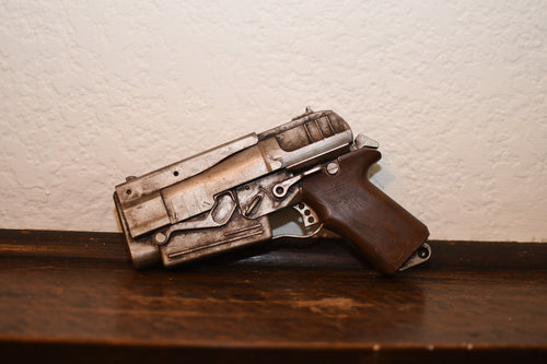 Toy gun on a wooden surface with a neutral background