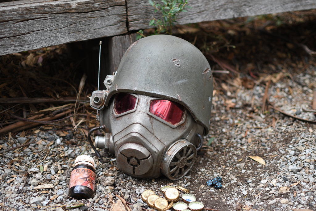 Vintage-style gas mask with red lenses on a gravel surface