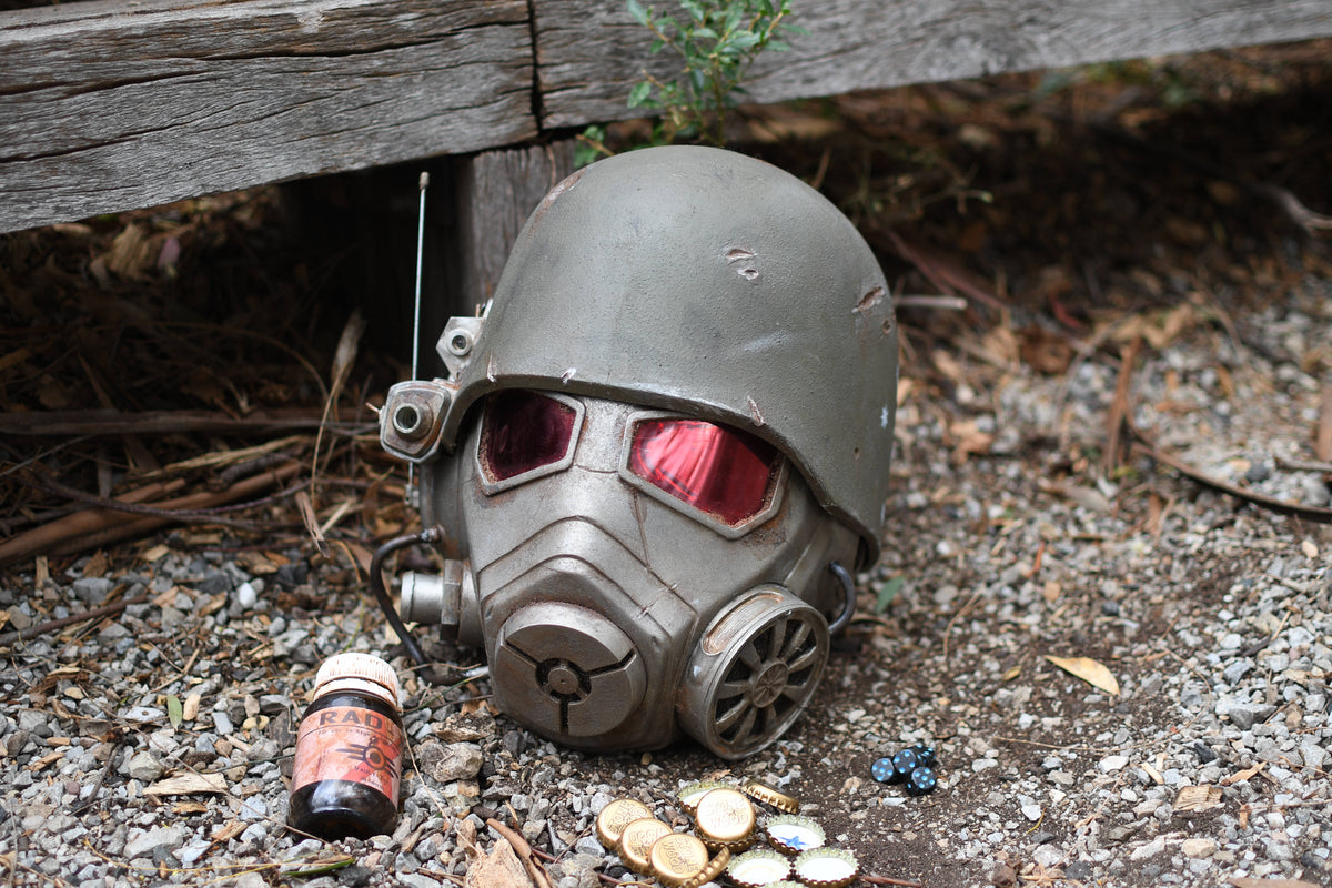 Vintage-style gas mask with red lenses on a gravel surface
