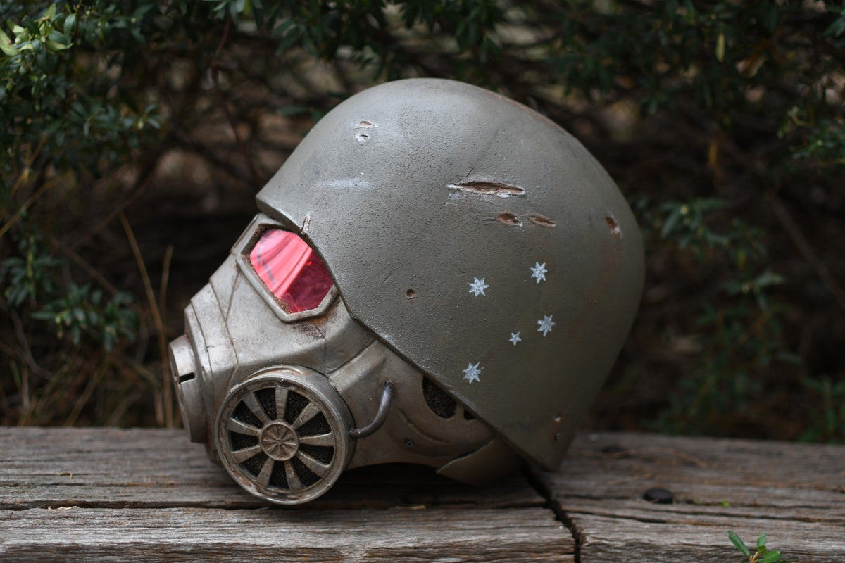 Vintage gas mask with red filter on a wooden surface with a natural background